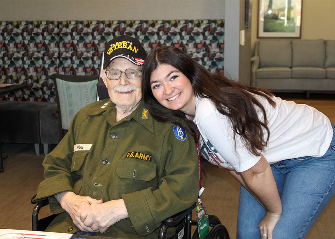 Young woman with veteran man in wheelchair