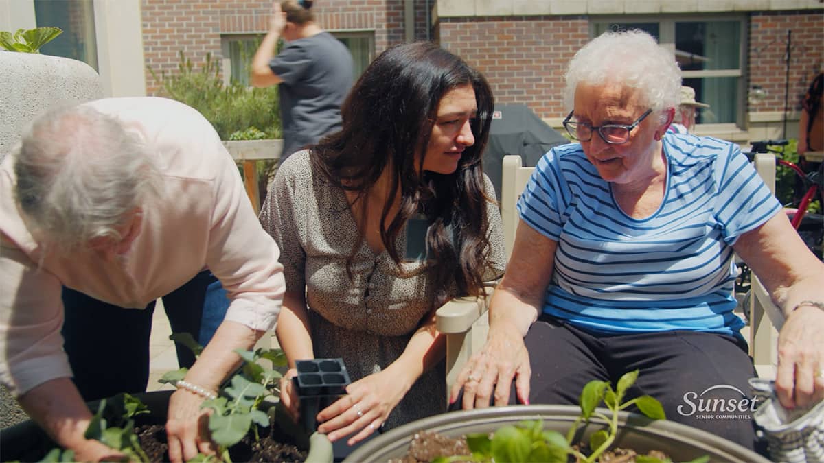 Elderly man and woman gardening with young woman