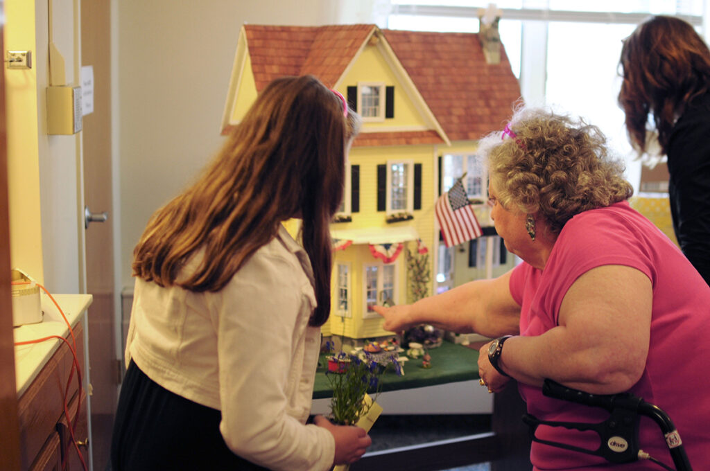 Generations interacting with a dollhouse.
